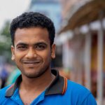 Close-up portrait of a smiling South Asian man in Natore, Bangladesh.